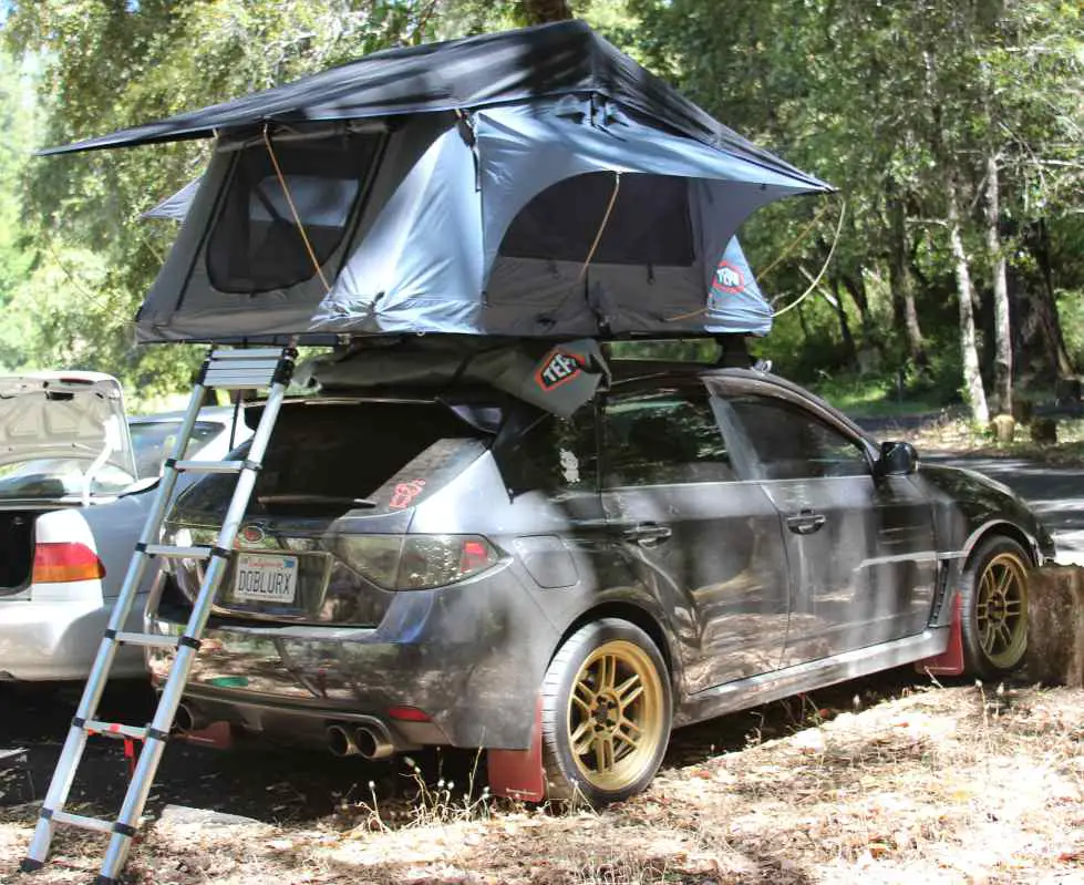 This man sleeping on top of his Subaru WRX with a Tepui rooftop tent is